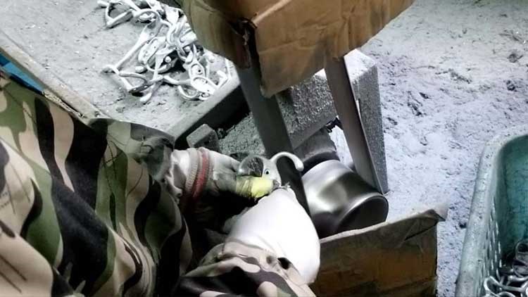 The sander is working, making the surface of the hook smoother